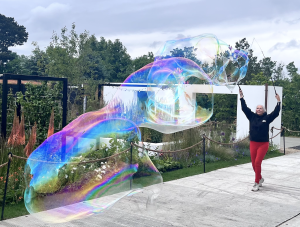Scientific Sue creating enormous rainbow-coloured bubbles using a giant wand at Bloom in the Park festival in Phoenix Park, Dublin