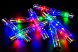 Several clear light-up sticks with silver ends glow red, blue and green against a black background.